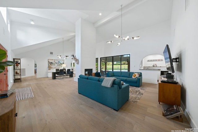 living room featuring high vaulted ceiling, light wood-type flooring, beamed ceiling, and an inviting chandelier