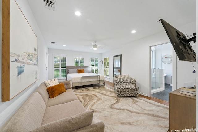 bedroom featuring hardwood / wood-style flooring, ceiling fan, and ensuite bath