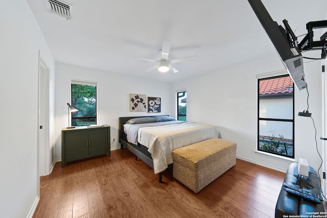 bedroom featuring wood-type flooring, multiple windows, and ceiling fan