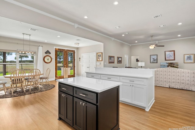 kitchen with a center island, pendant lighting, light countertops, visible vents, and open floor plan