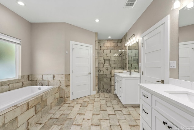 full bath featuring a garden tub, recessed lighting, two vanities, visible vents, and tiled shower