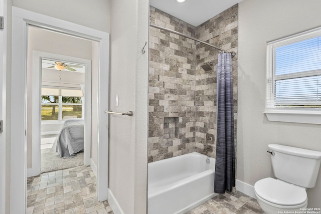 ensuite bathroom featuring toilet, baseboards, shower / bath combo with shower curtain, and ensuite bathroom