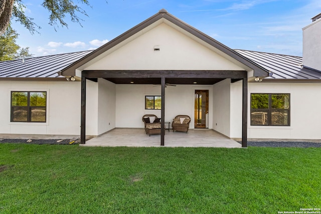 back of property with a standing seam roof, metal roof, and a patio