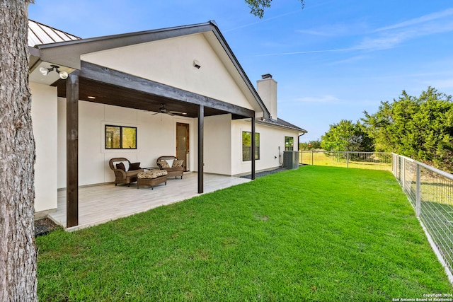 rear view of house featuring an outdoor fire pit, a fenced backyard, a lawn, and stucco siding