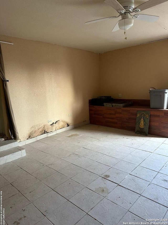 spare room with ceiling fan and light tile patterned floors