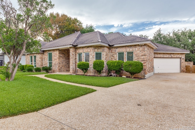 single story home featuring a garage and a front lawn