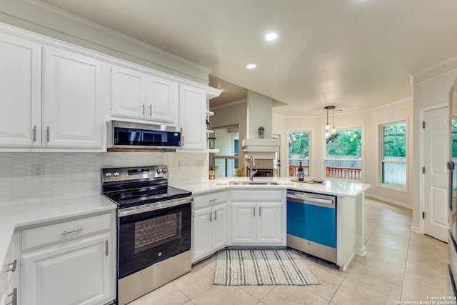 kitchen with pendant lighting, sink, white cabinets, and appliances with stainless steel finishes