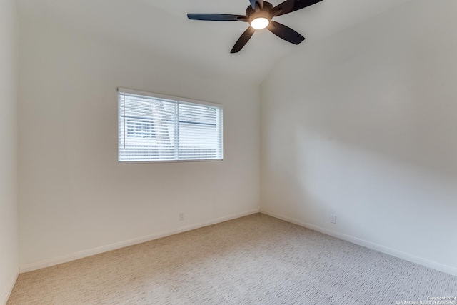 spare room featuring ceiling fan, lofted ceiling, and light carpet