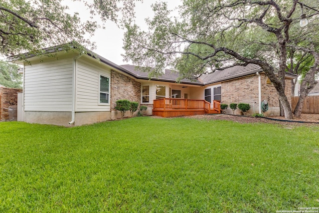 rear view of property with a deck and a lawn