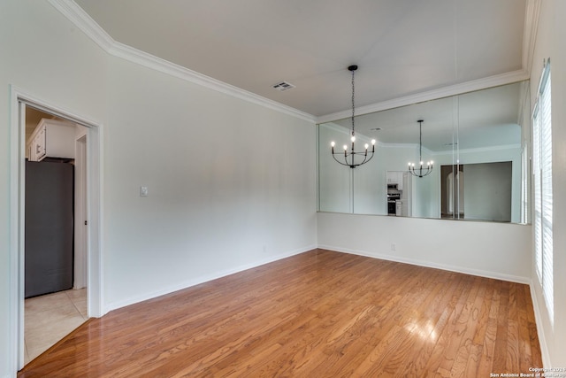 unfurnished room with crown molding, a notable chandelier, and light wood-type flooring