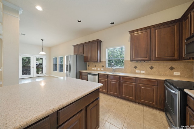 kitchen with stainless steel appliances, french doors, decorative backsplash, sink, and light tile patterned floors