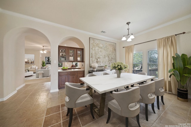 dining space featuring ceiling fan with notable chandelier and ornamental molding