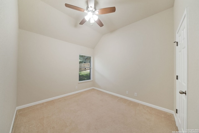 carpeted spare room with ceiling fan and lofted ceiling