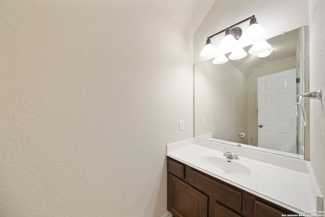 bathroom with vanity and vaulted ceiling