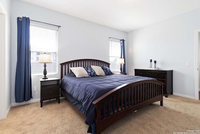 bedroom with baseboards and light colored carpet