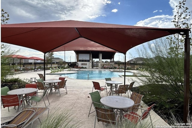 pool with a patio area and fence