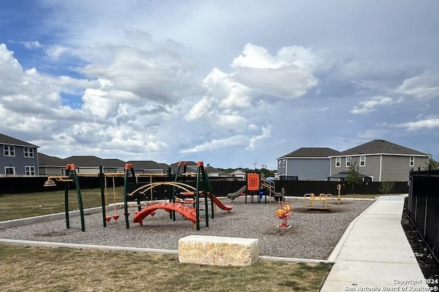 community play area featuring fence and a residential view