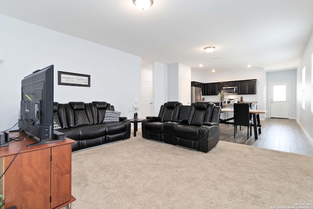 living room featuring recessed lighting, light colored carpet, and baseboards