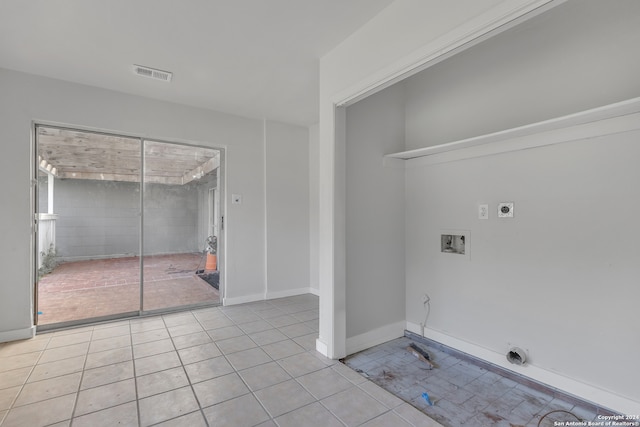 clothes washing area featuring electric dryer hookup, hookup for a washing machine, and light tile patterned floors