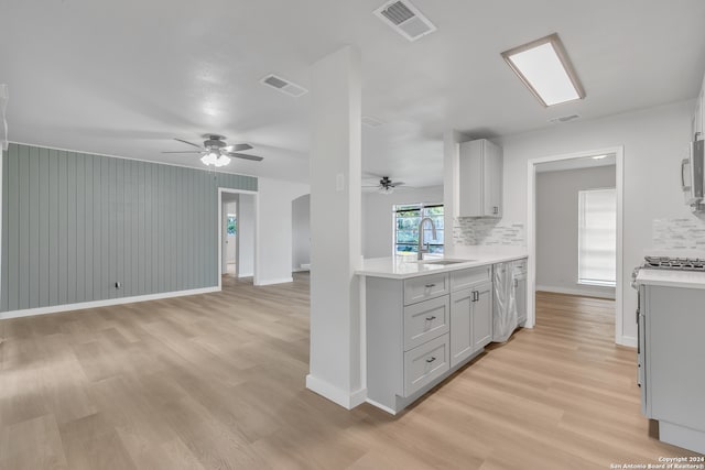 kitchen with sink, ceiling fan, light hardwood / wood-style flooring, and tasteful backsplash