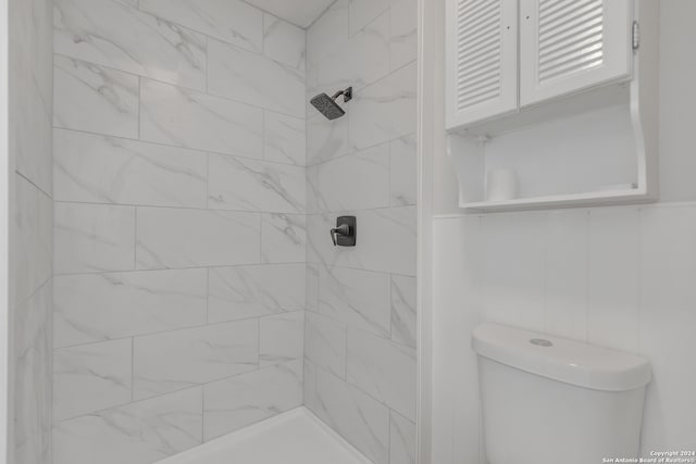 bathroom with toilet and a tile shower