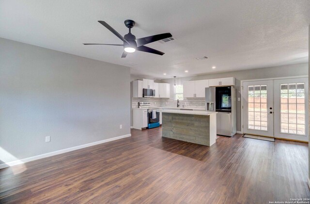 kitchen with dark hardwood / wood-style flooring, white cabinets, a center island, french doors, and appliances with stainless steel finishes