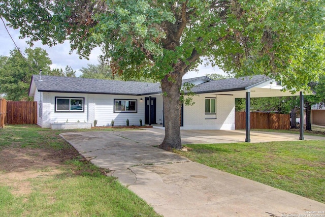 ranch-style house featuring a carport and a front lawn