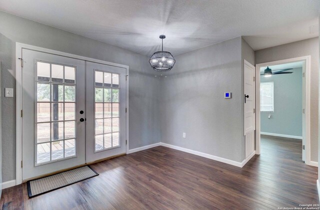 doorway featuring french doors, ceiling fan with notable chandelier, and wood-type flooring