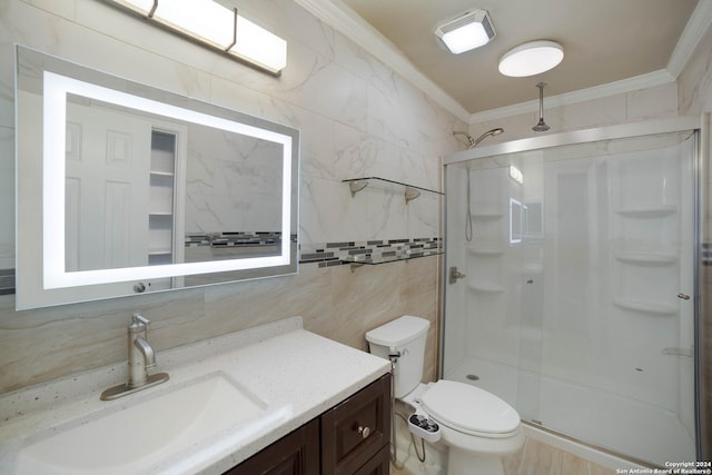 bathroom with a shower stall, toilet, ornamental molding, tile walls, and vanity