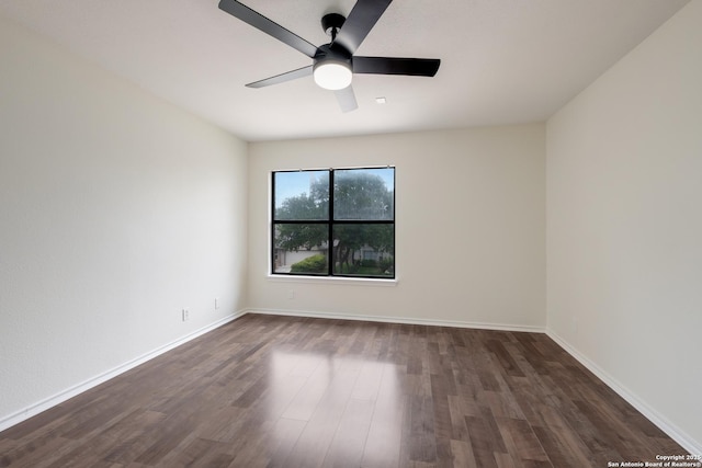 empty room featuring dark wood-style floors, baseboards, and a ceiling fan