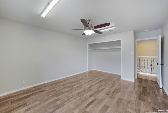 unfurnished bedroom featuring ceiling fan, a closet, and light hardwood / wood-style flooring