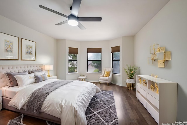 bedroom with dark wood-style floors, baseboards, and ceiling fan