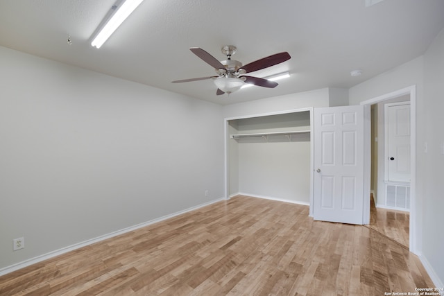 unfurnished bedroom featuring a closet, light wood-type flooring, and ceiling fan