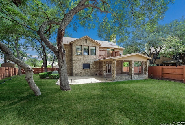 back of property featuring a lawn, a balcony, a patio, and a fenced backyard