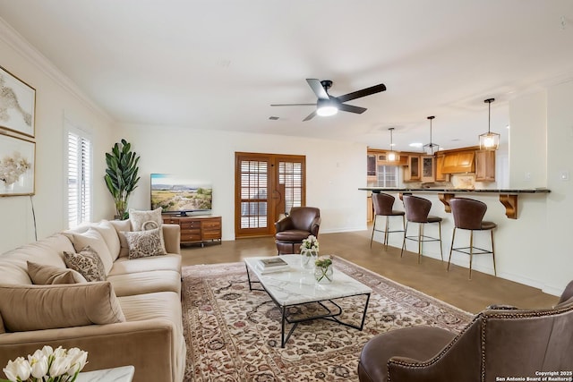 living area featuring crown molding, visible vents, ceiling fan, and baseboards