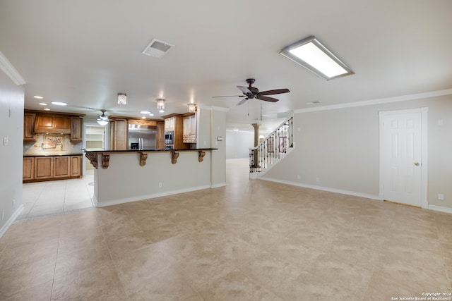 unfurnished living room featuring light tile patterned floors and ornamental molding