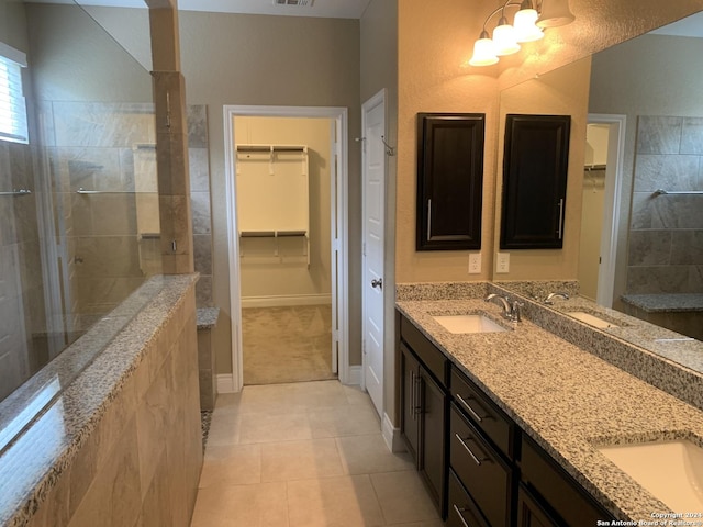 bathroom featuring vanity, a shower, and tile patterned floors