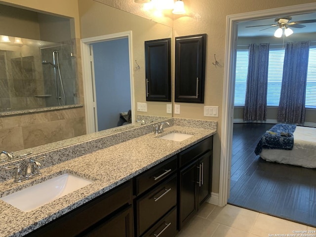 bathroom featuring ceiling fan, vanity, tiled shower, and tile patterned flooring