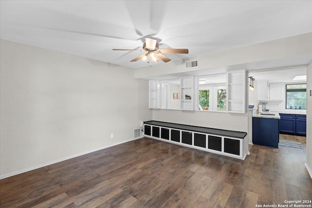 unfurnished living room featuring ceiling fan, plenty of natural light, dark hardwood / wood-style floors, and sink