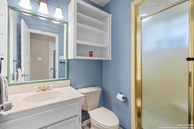 bathroom with a shower with shower door, built in shelves, toilet, and vanity