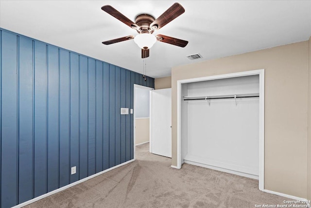 unfurnished bedroom with light carpet, ceiling fan, and a closet