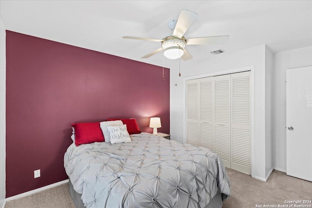 carpeted bedroom featuring a closet and ceiling fan