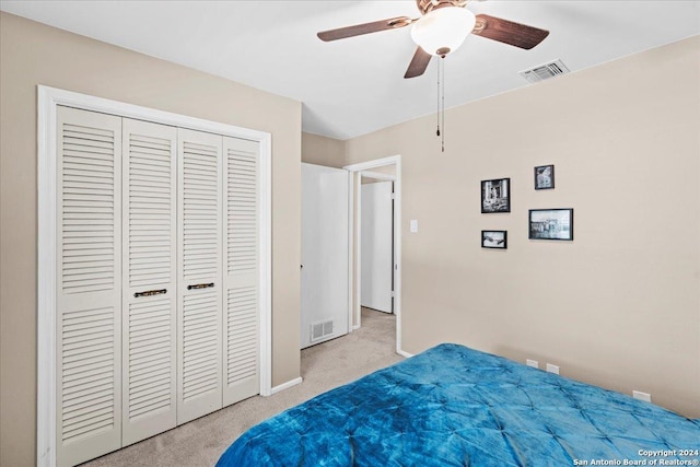 bedroom with ceiling fan, a closet, and light carpet