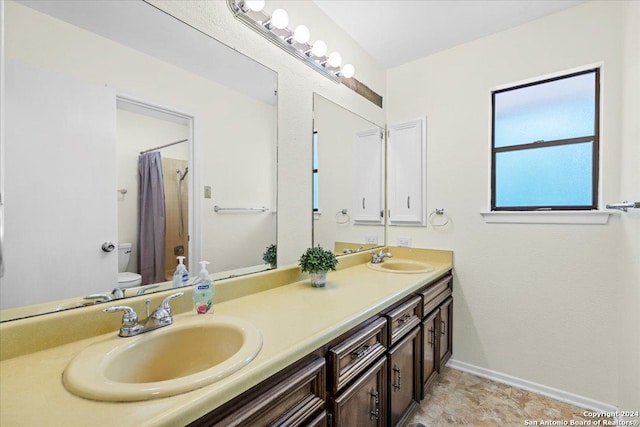 bathroom featuring toilet, a shower with shower curtain, and vanity