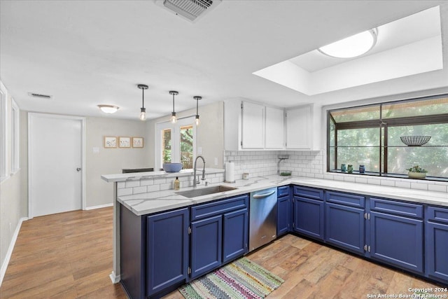 kitchen with kitchen peninsula, sink, blue cabinetry, and white cabinetry