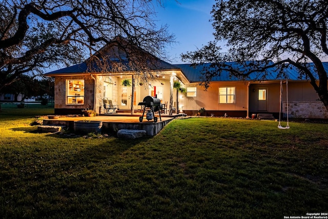 rear view of property featuring stone siding and a yard