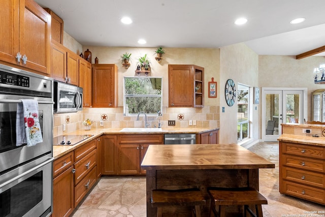 kitchen with sink, light tile patterned flooring, a wealth of natural light, and stainless steel appliances