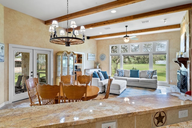 dining space with french doors, visible vents, beamed ceiling, and a fireplace with raised hearth