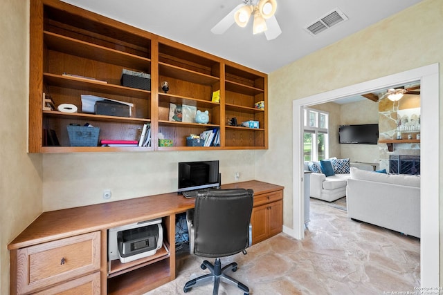 home office with ceiling fan, built in study area, and visible vents