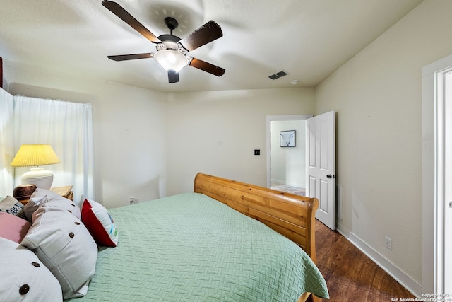 bedroom featuring a ceiling fan, baseboards, visible vents, and wood finished floors